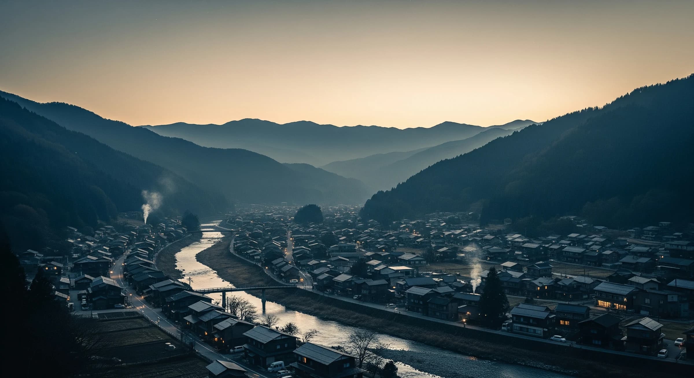夕暮れの山あいの集落と棚田